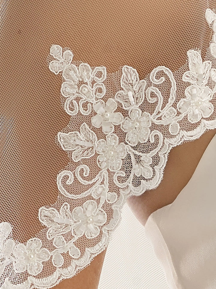 Voile de mariée en tulle doux avec bordure de dentelle perlée existe en blanc ou en ivoire vu de détail de la dentelle