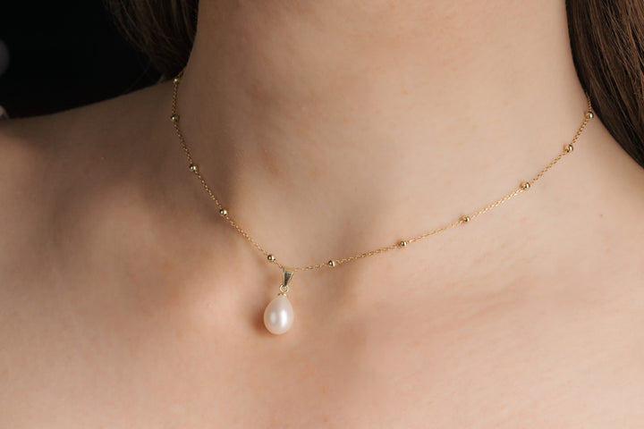 Collier de dos Seville, perle sur le devant, finition or