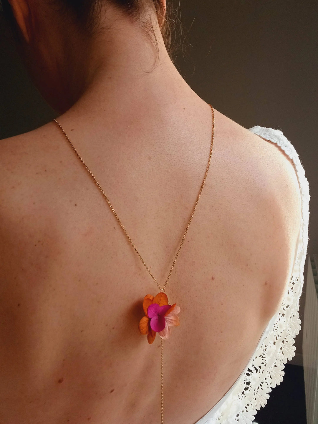 Collier de dos doré à fleurs fuchsia, orange, vieux rose. L'atelier du 6