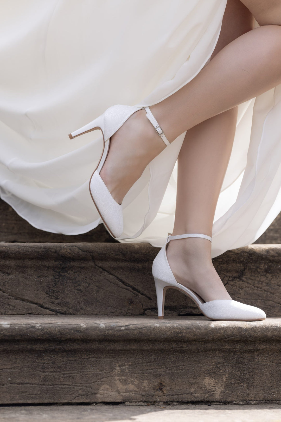 Escarpin de mariée Autumn avec sa bride de cheville ivoire sous une robe de mariée