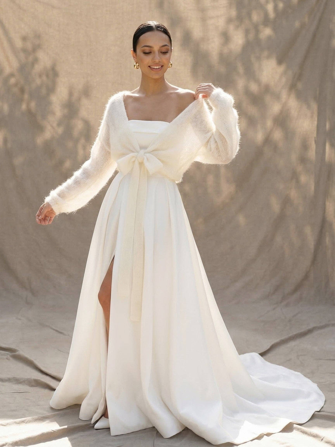 Cache-cœur en mohair ivoire porté sur une robe de mariée en satin