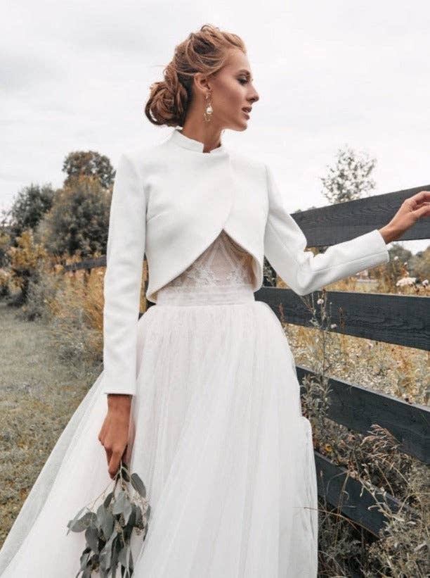 Veste de mariée courte en laine et cachemire ivoire, col officier, portée ouverte sur une robe en tulle