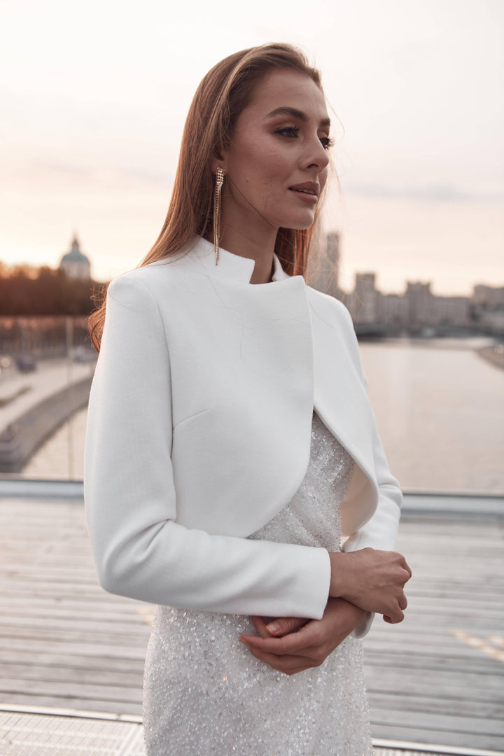 Veste de mariée courte ivoire portée sur une robe de mariée à jupe ample