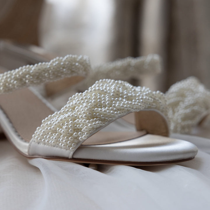 Mariée portant les mules Pearl brodées de perles sous sa robe