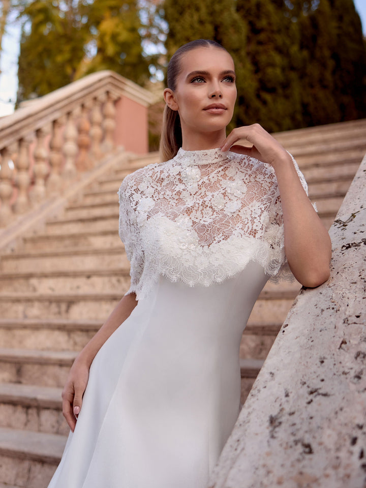 Poncho de mariée E536 en dentelle porté sur une robe de mariée