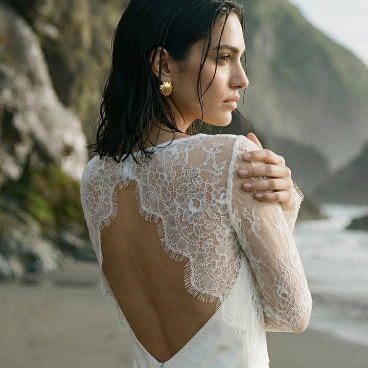 Top de mariée en dentelle blanche à manches longues porté sur une robe nuisette