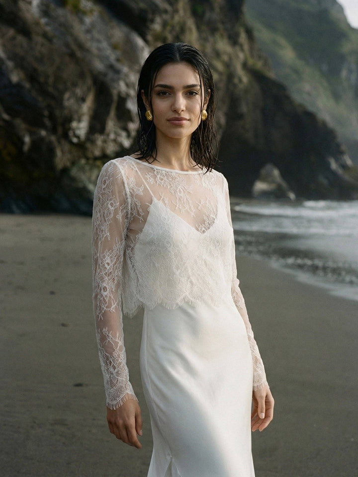 Mariée en top de dentelle blanche au bord de l'eau