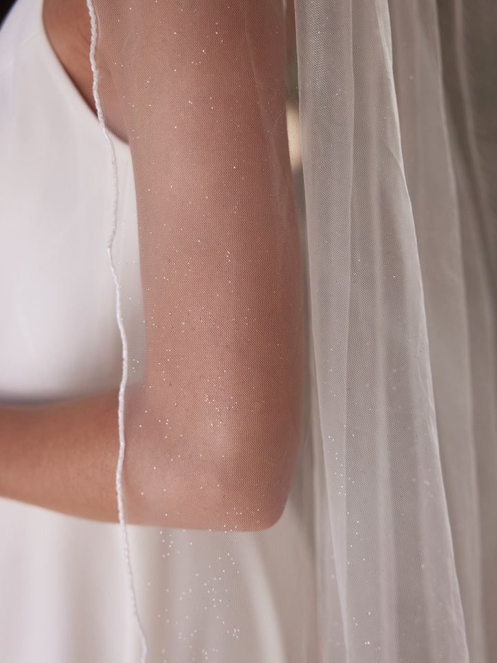 Détail de la bordure en perles de verre et du tulle pailleté du voile de mariée S521 Bianco Evento
