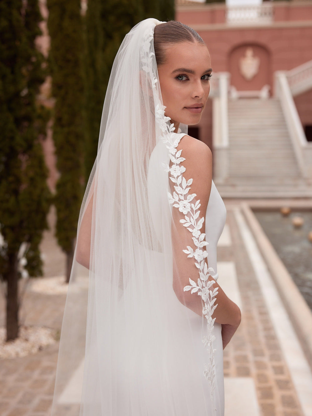 Détail de la guirlande de fleurs et de feuillages en dentelle découpée du voile de mariée S563 Bianco Evento