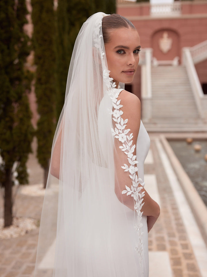 Détail de la guirlande de fleurs et de feuillages en dentelle découpée du voile de mariée S563 Bianco Evento