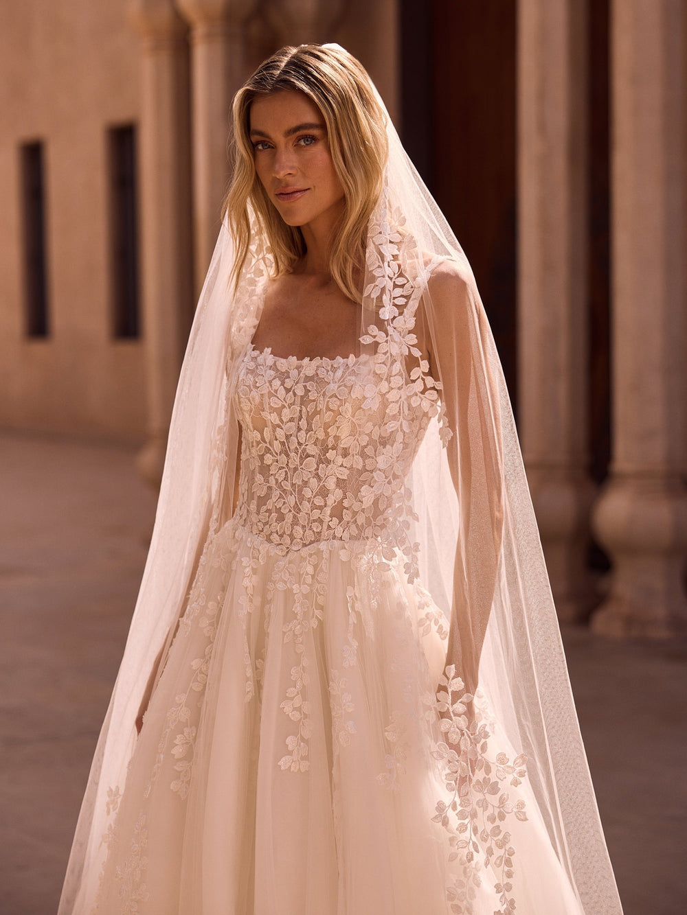 Détail des applications de fleurs de dentelle en relief posées en semis sur le voile de mariée S575 Bianco Evento